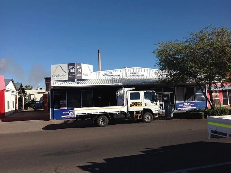 A Flatbed Truck Parked in Front of a One-story Commercial Building — Mt Isa Four Wheel Drive Services in Mount Isa City, QLD