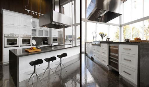 Une cuisine avec armoires blanches et électroménagers en acier inoxydable et un grand îlot.