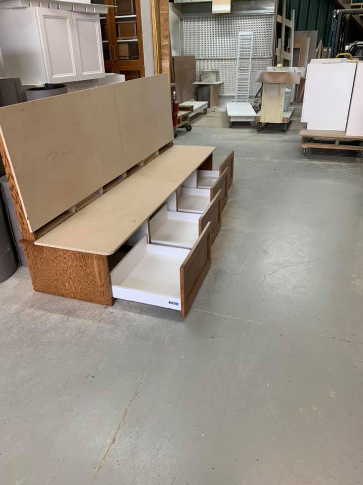 Un banc en bois avec des tiroirs en dessous dans un entrepôt.