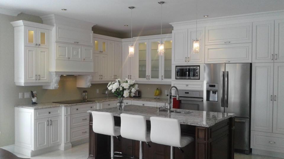Une cuisine avec des armoires blanches et des appareils électroménagers en acier inoxydable