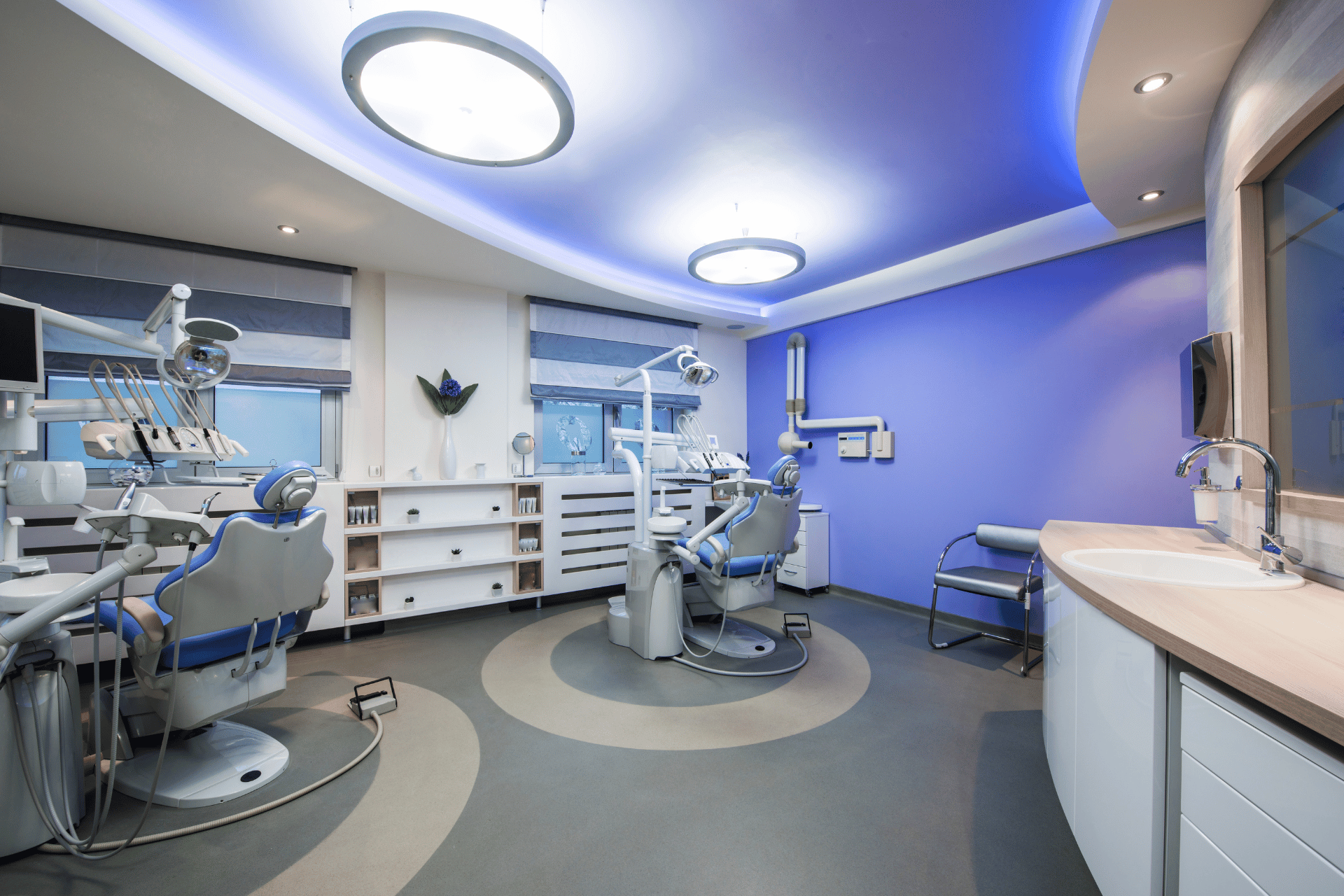 A dental office with a blue ceiling and a sink.