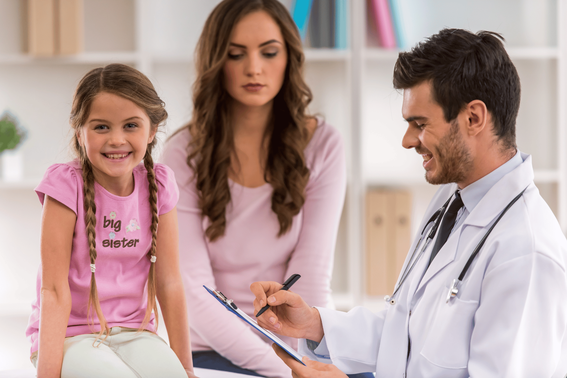 A doctor is talking to a woman and a little girl.