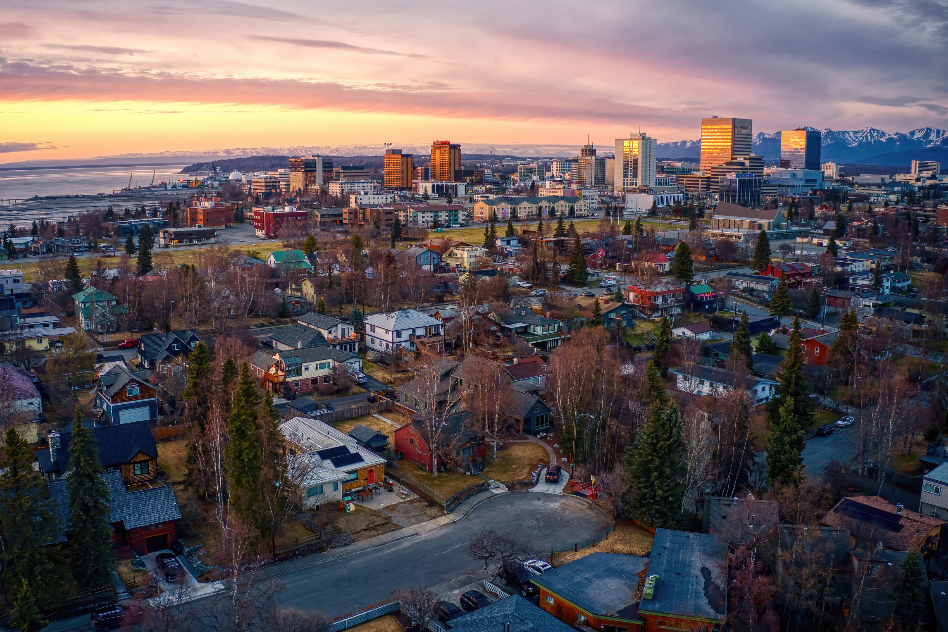 An aerial view of a city with a sunset in the background.