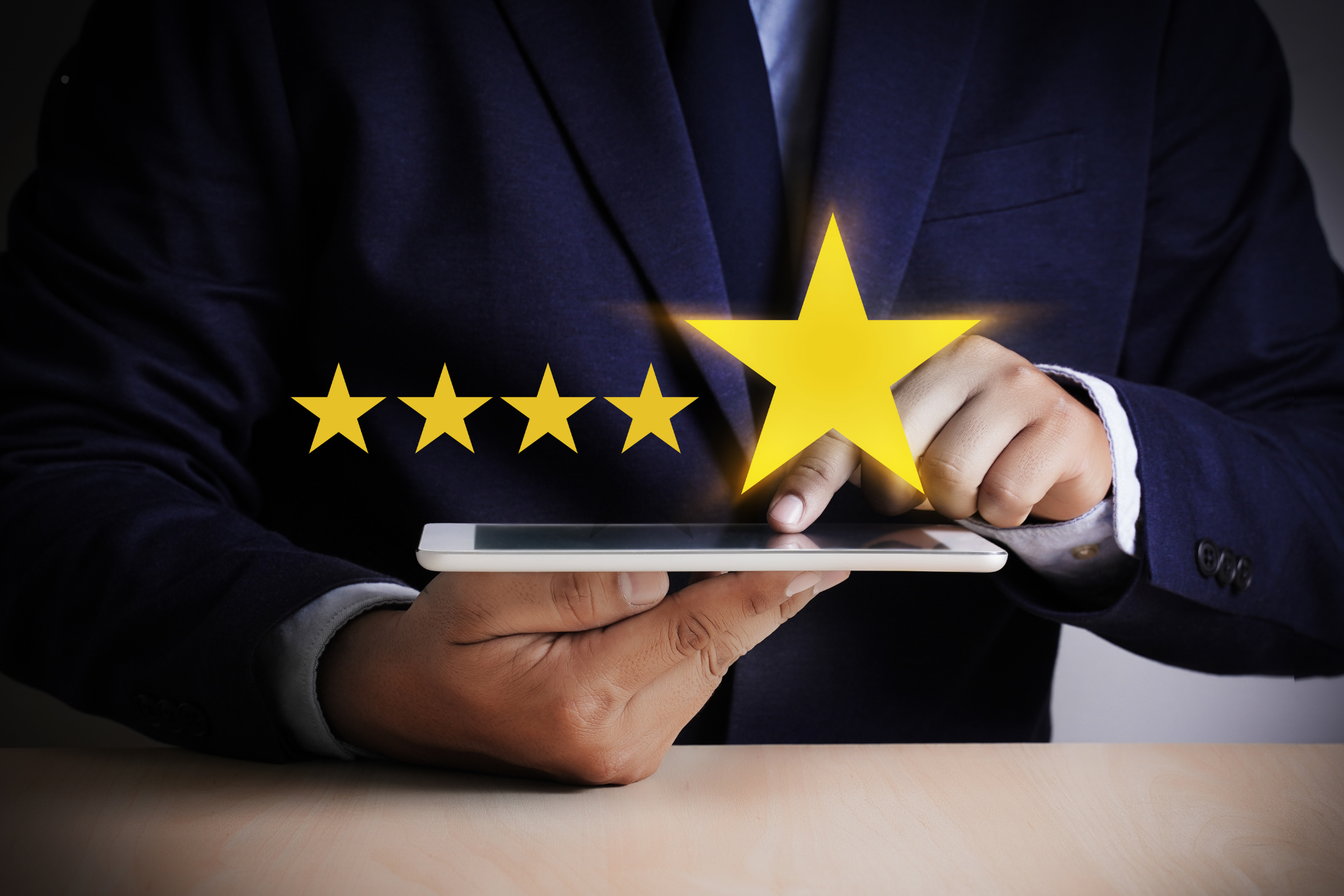 A man in a suit is holding a tablet with a star on it.