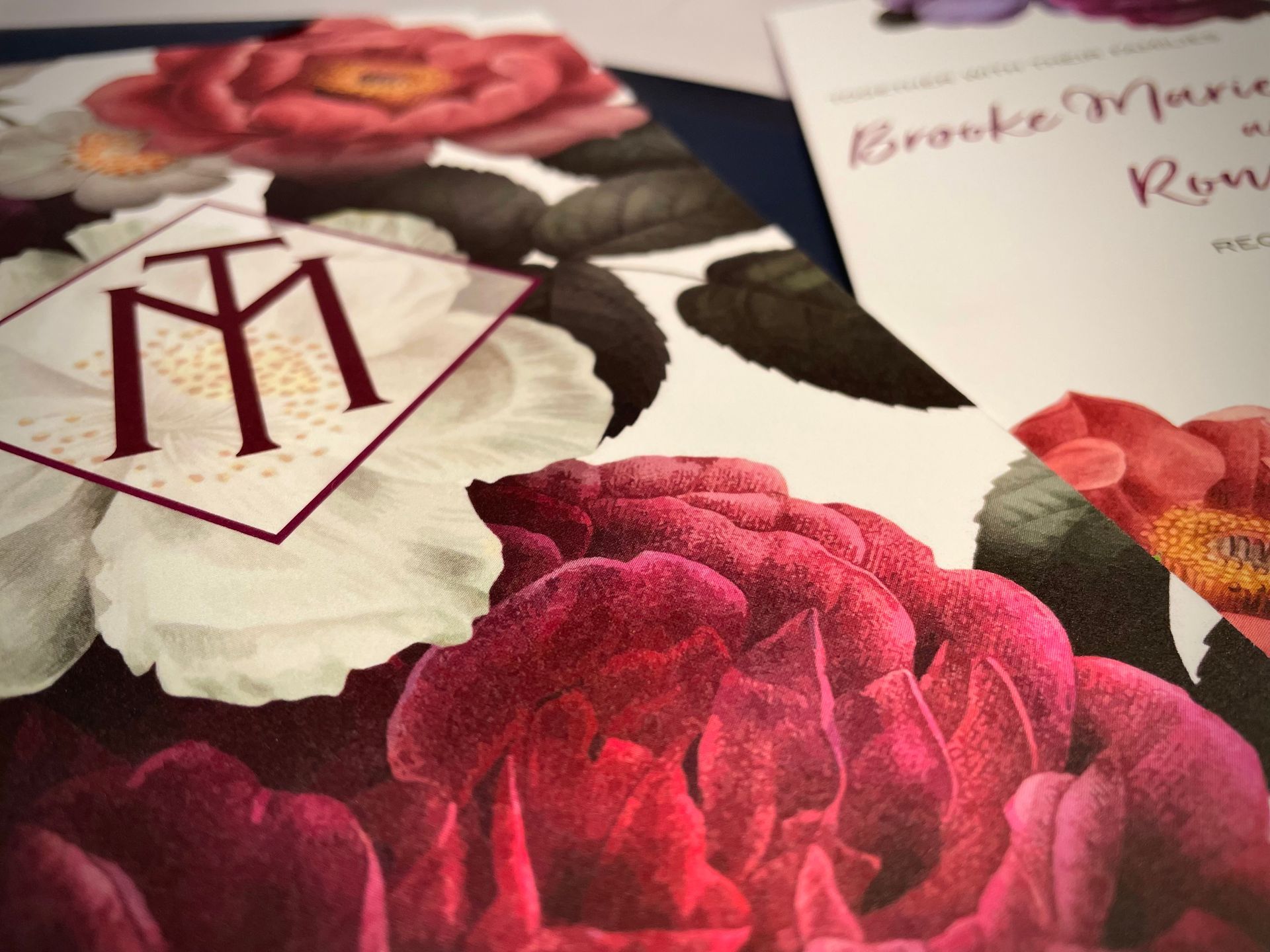 a closeup of a wedding invitation for brooke and ronnie. floral and monogram styled