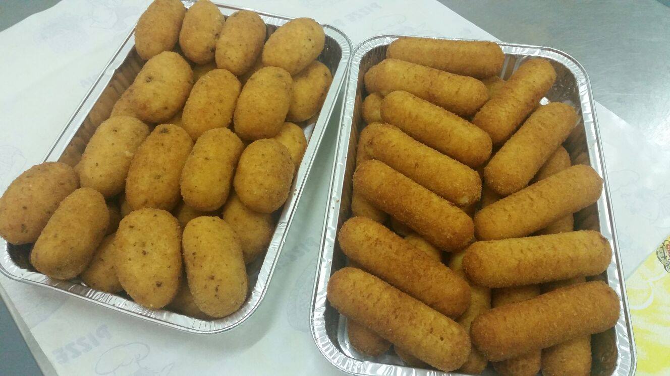 due vassoi con crocchette e arancini