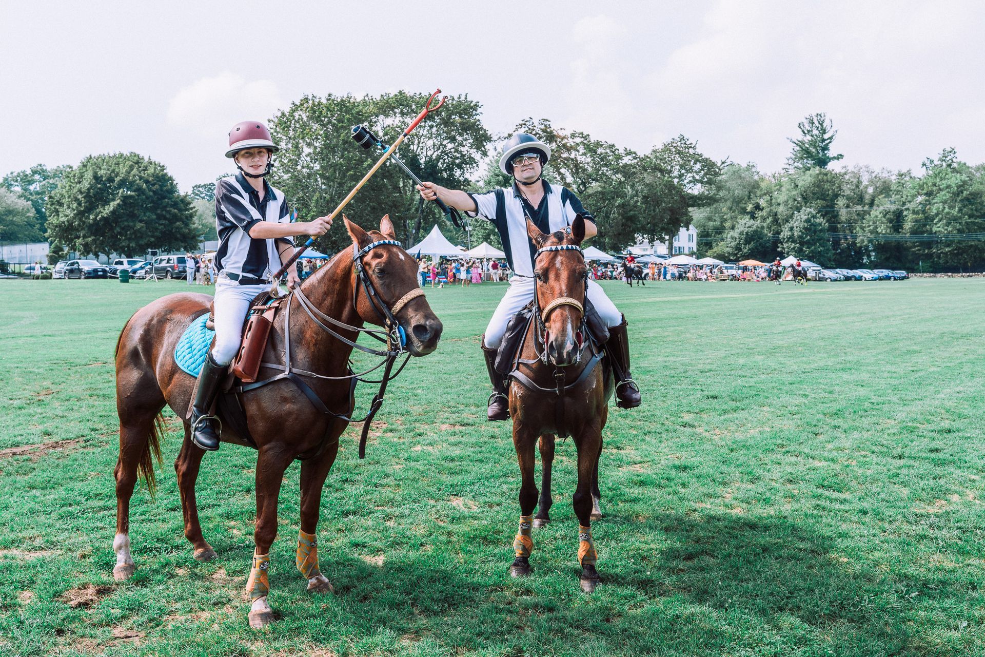 Two people are riding horses in a field.