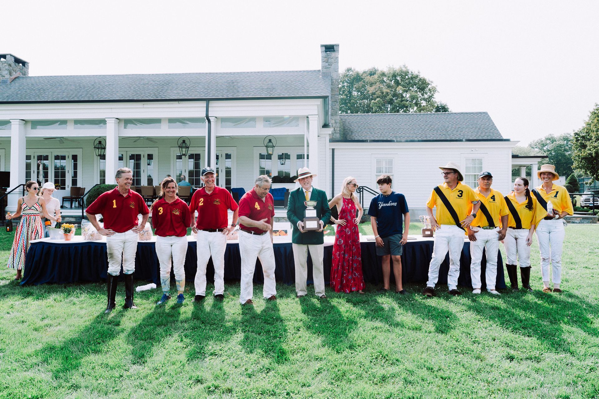 A group of people are posing for a picture in front of a white house.