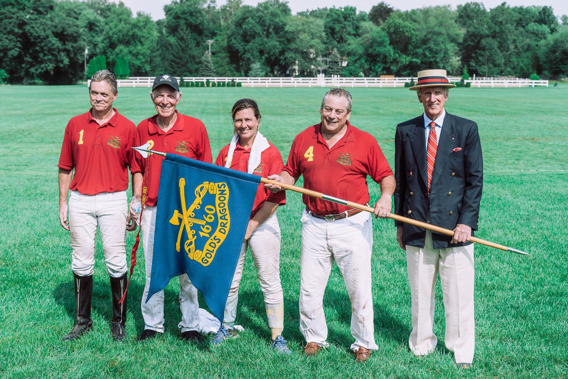 A group of people standing in a field holding a flag