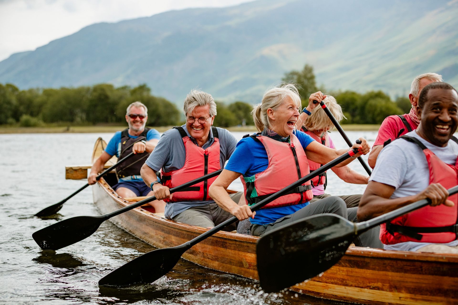 A group of people are rowing a canoe on a lake.