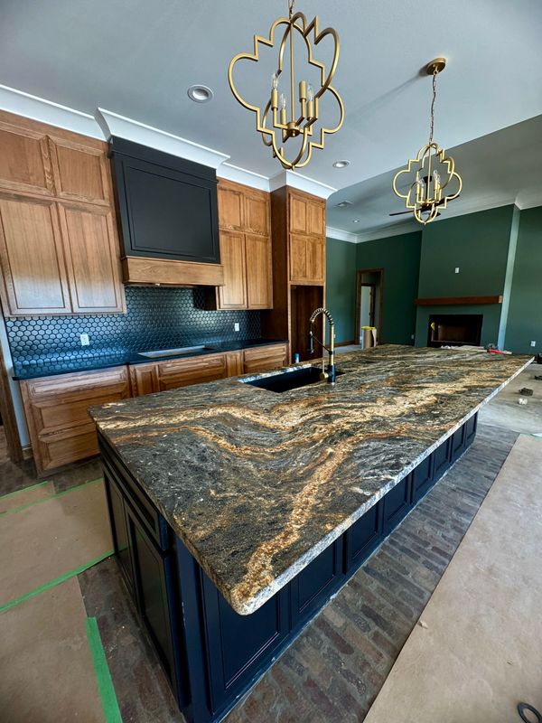 A kitchen with a large island and granite counter tops.