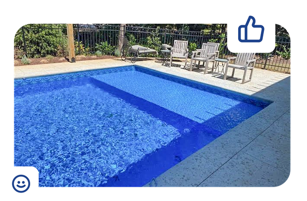 Blue tiled swimming pool with three white chairs on the deck.