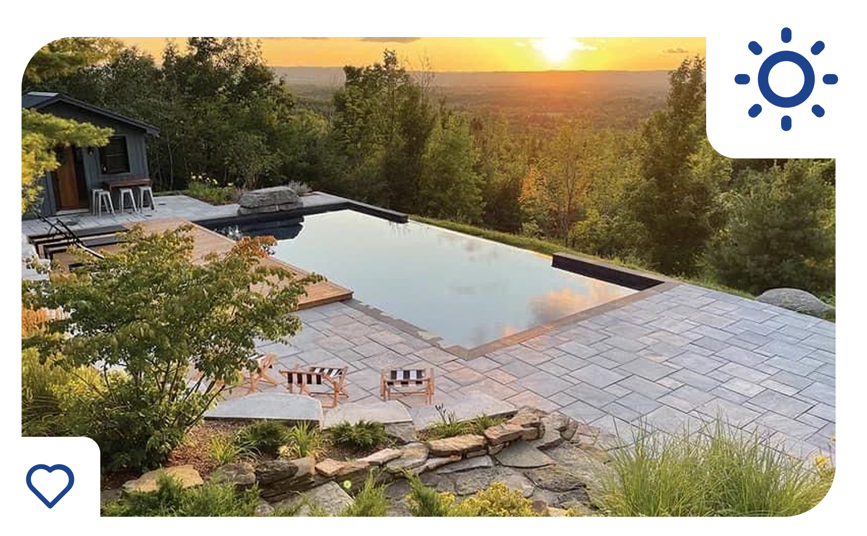 Infinity pool overlooking a sunset, surrounded by trees and stone patio.