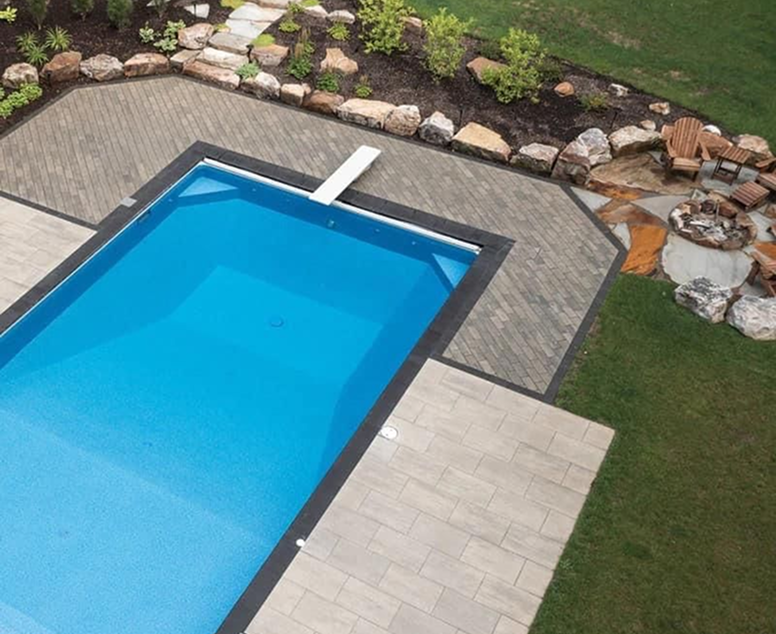 Backyard with rectangular pool, patio, lawn, landscaping, and a fire pit.