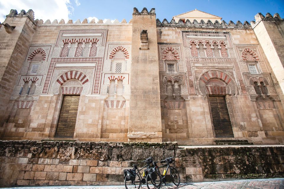 Two bikes parked in front of the Moorish outer wall of La Mezquita in Cordoba