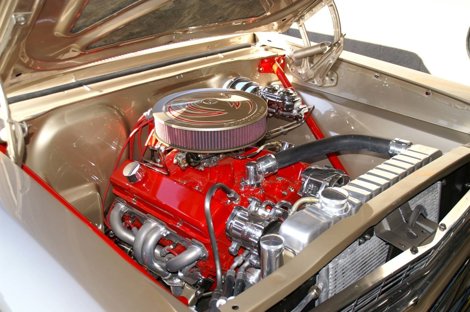 A close up of a car engine with the hood open