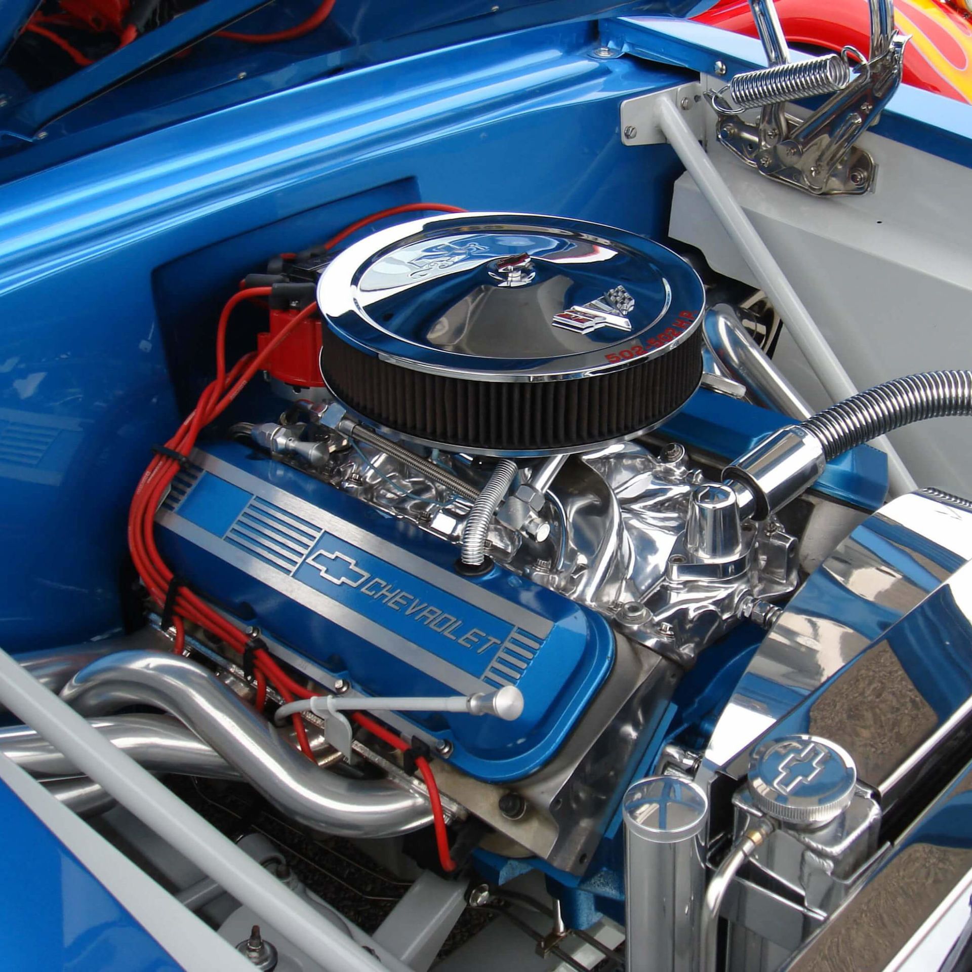 A blue chevrolet engine is shown with the hood open
