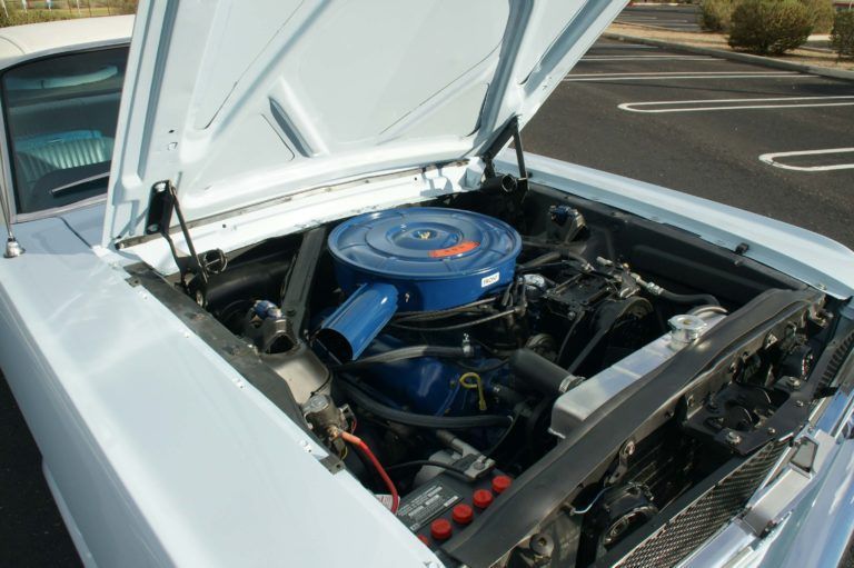 The hood of a car is open and the engine is visible