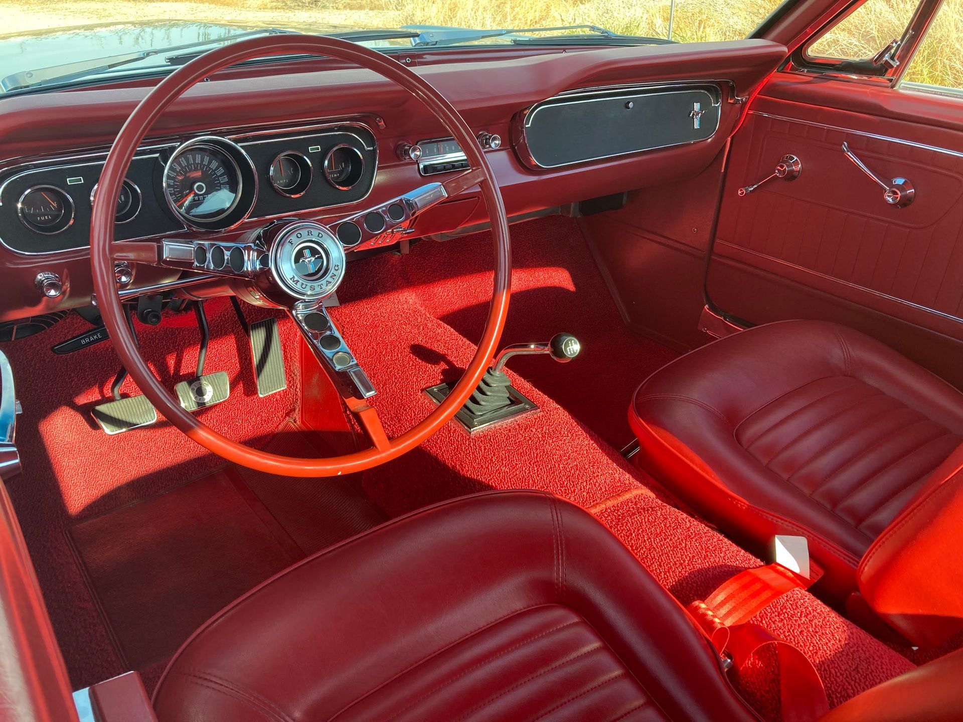 A red car with a steering wheel and red seats