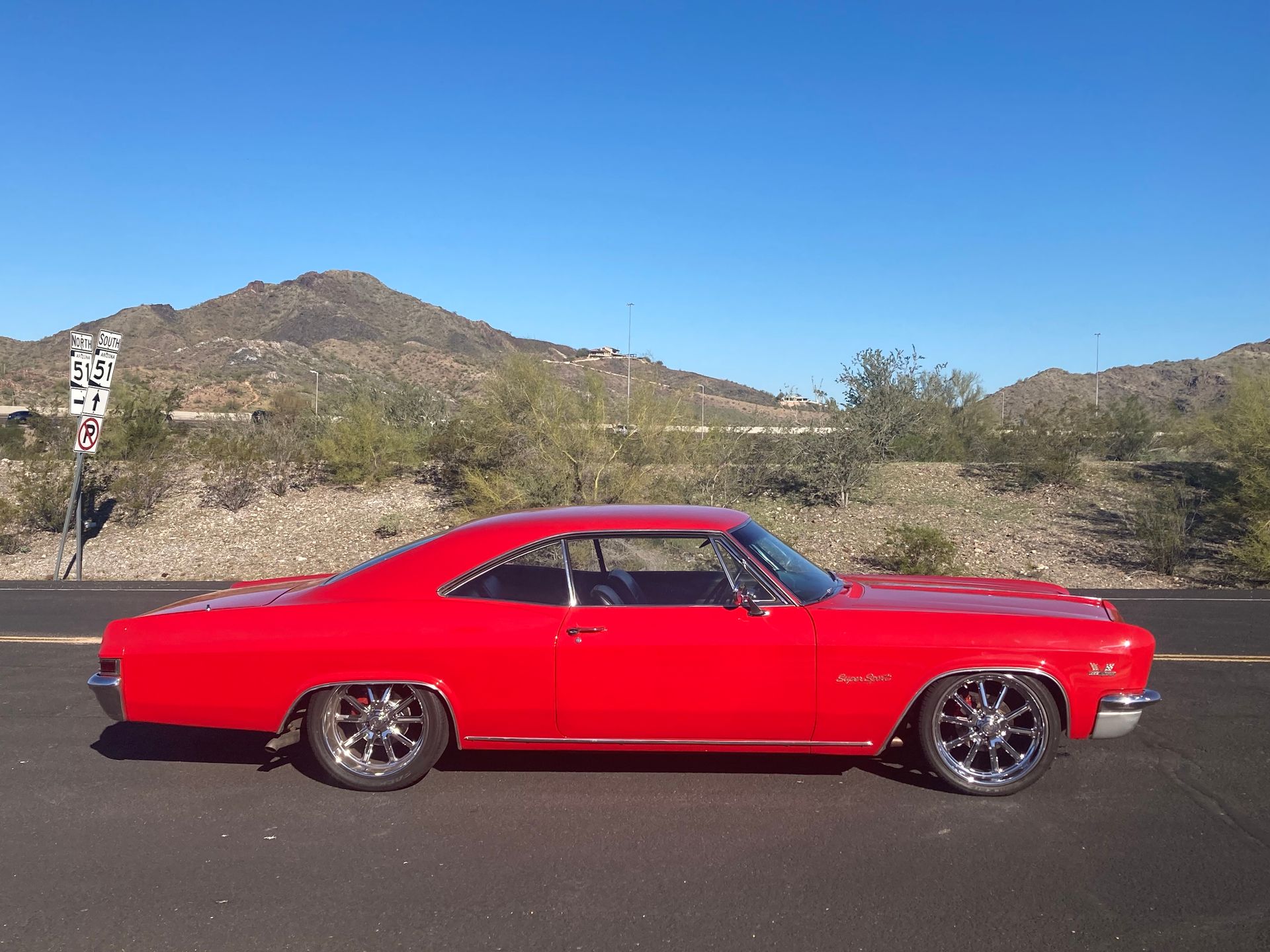 A red car is parked on the side of the road