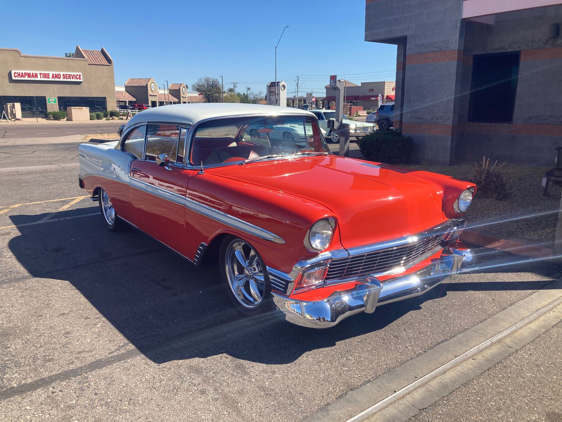 A red and white car is parked in a parking lot