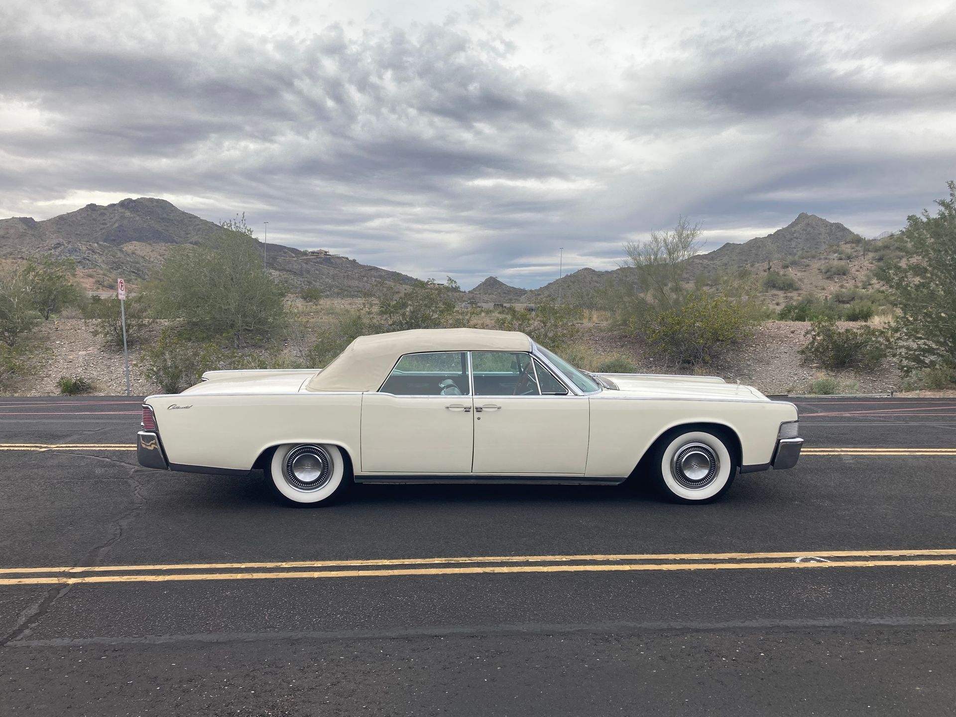 A white car is parked on the side of the road.