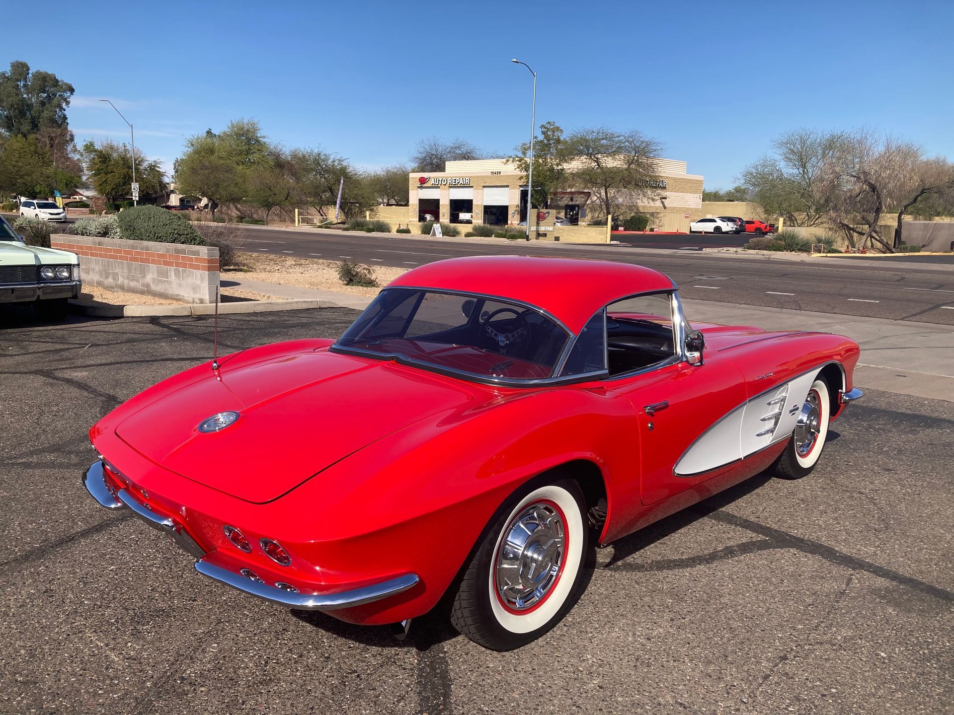 A red corvette is parked on the side of the road.