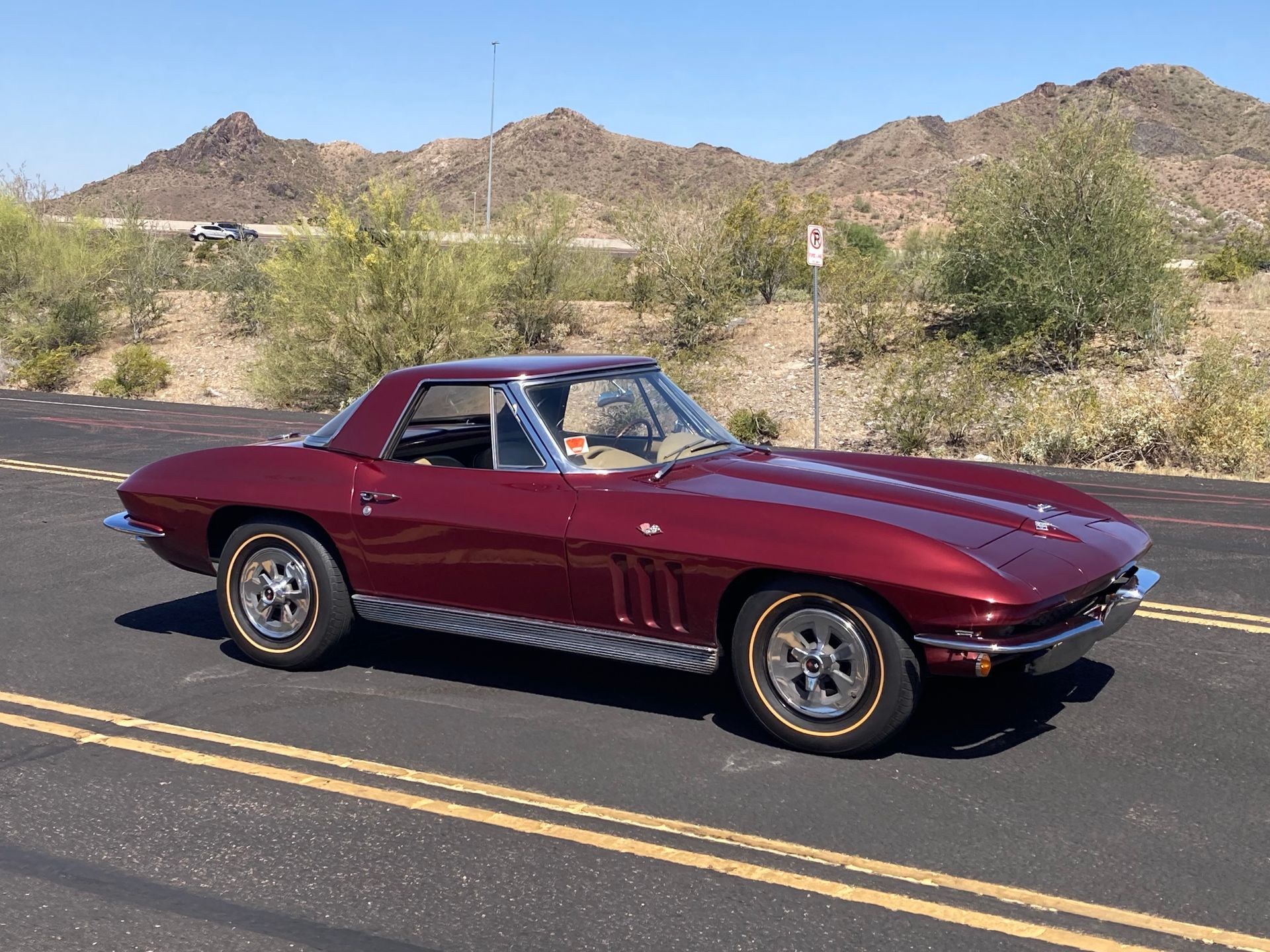 A red corvette is parked on the side of the road.