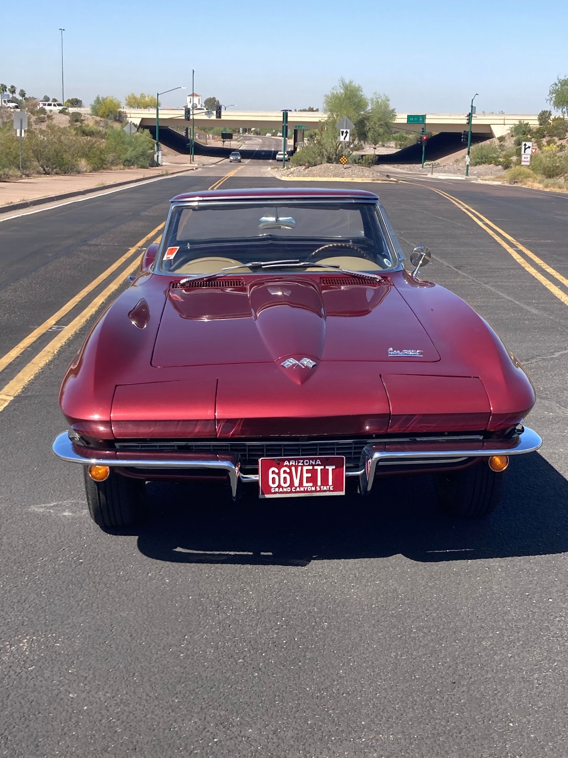 A red corvette is parked on the side of the road