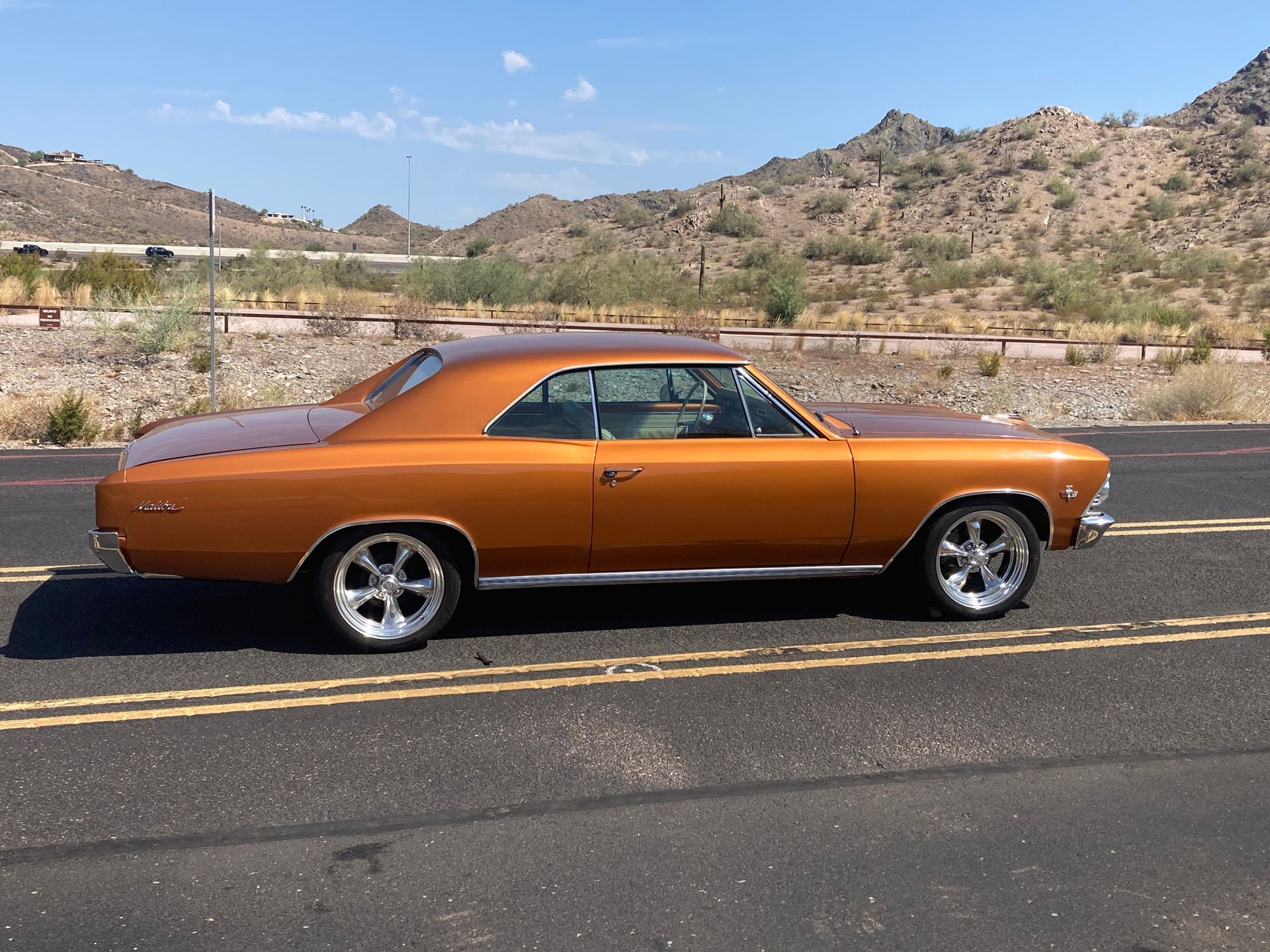 An orange car is parked on the side of the road