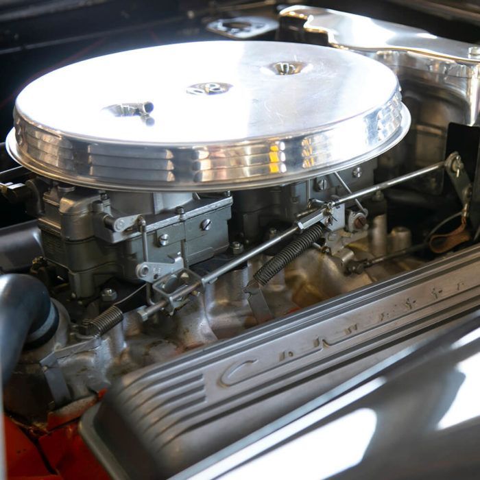 A close up of a corvette engine with a carburetor