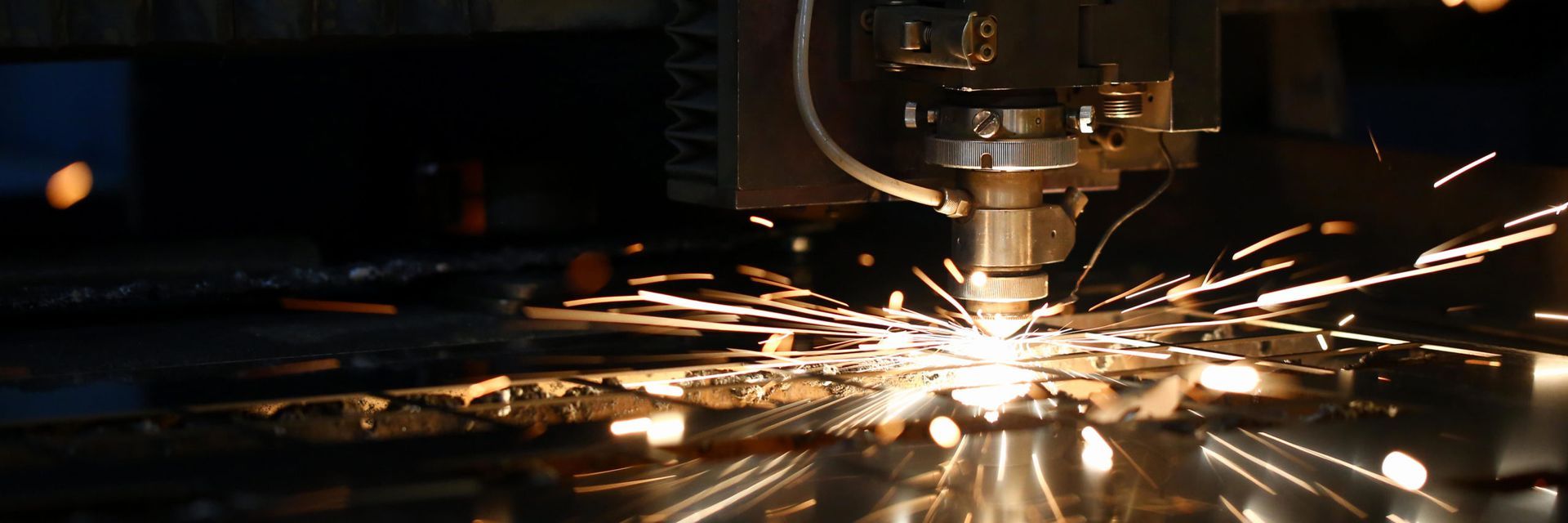 A machine is cutting a piece of metal with sparks coming out of it.