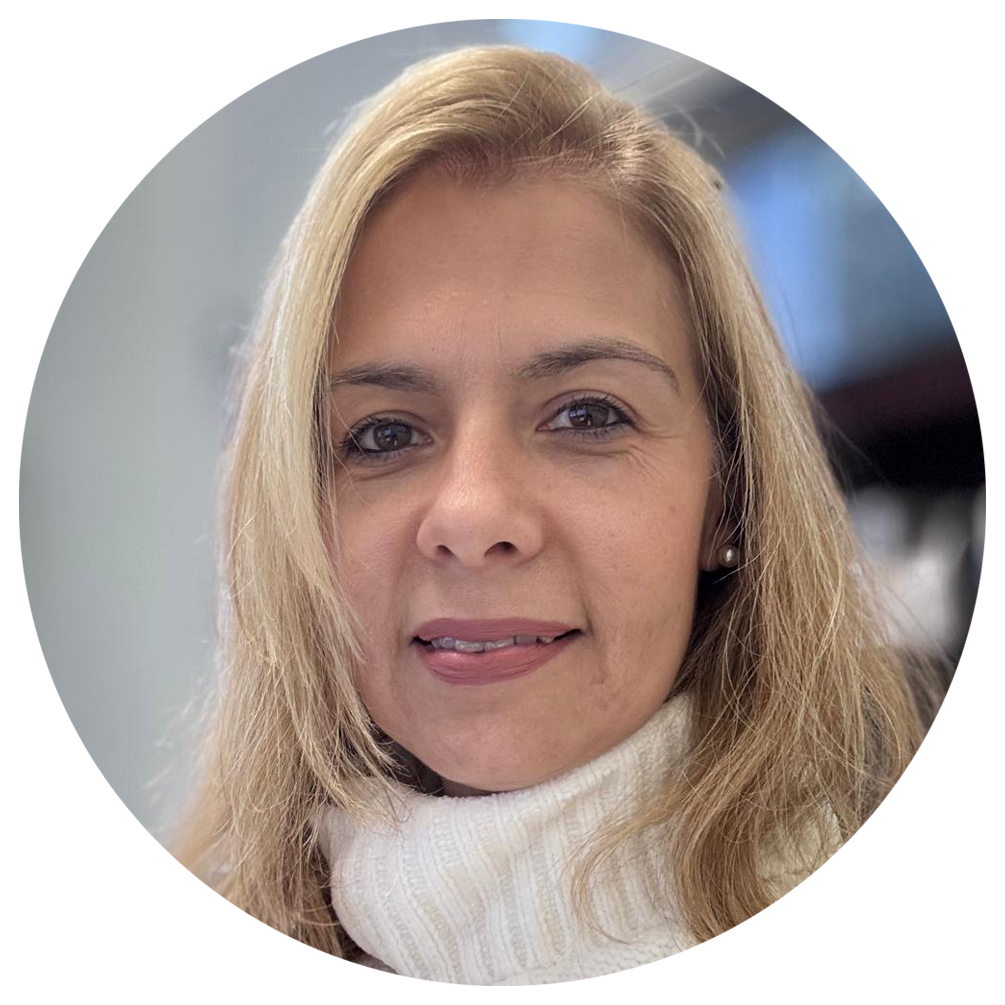Isabel with light brown hair wearing a white turtleneck, smiling.