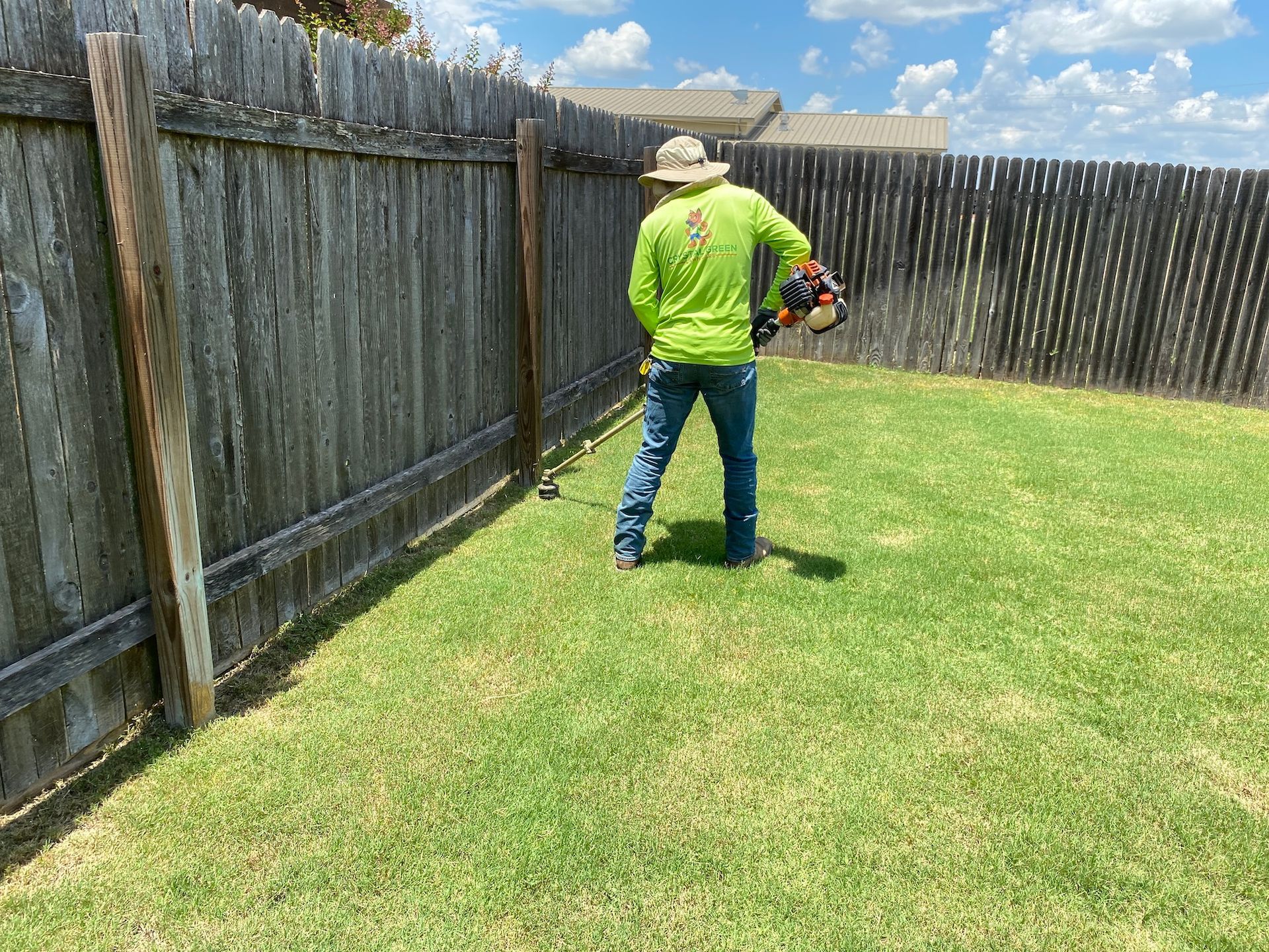 a man is standing in the grass holding a lawn mower .
