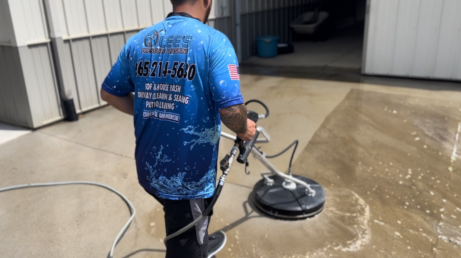 a man in a blue shirt is cleaning a concrete floor with a machine .