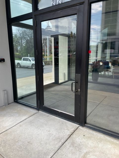Exterior glass door with black frame and handle on a building entrance.