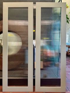 Two light grey interior doors with vertical ribbed glass panels.