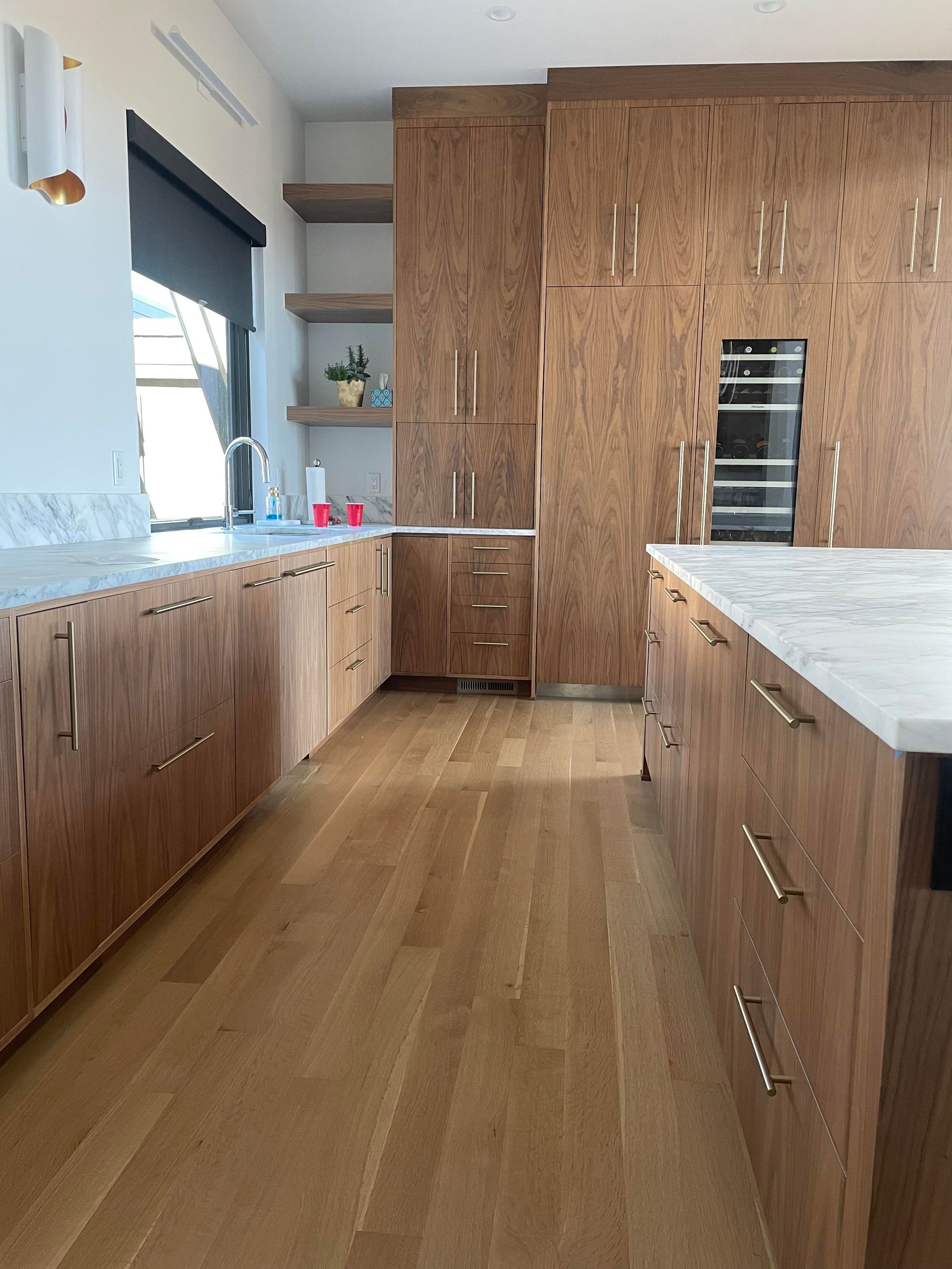 A kitchen with wooden cabinets and marble counter tops.