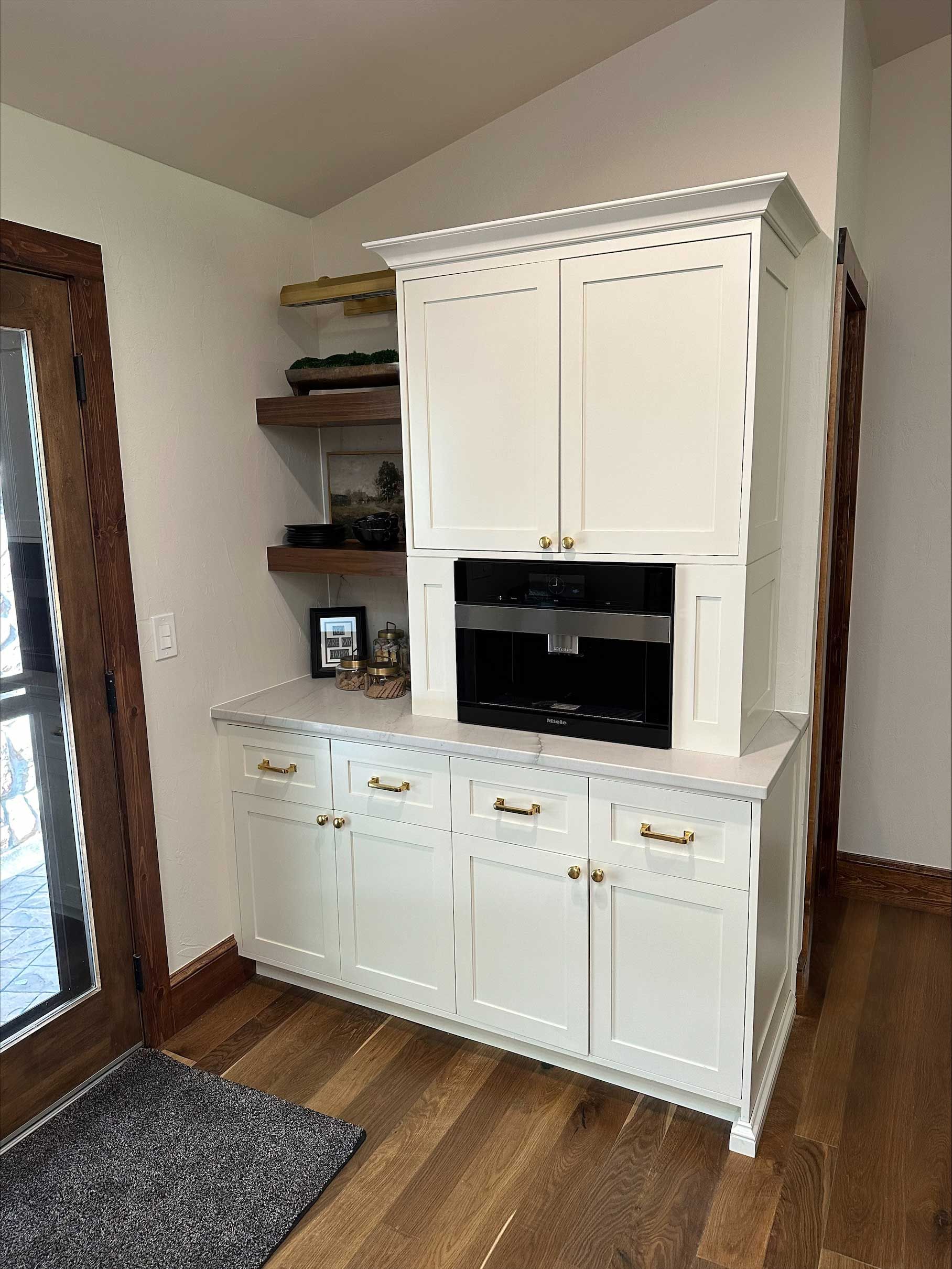 A kitchen with white cabinets and a coffee maker.