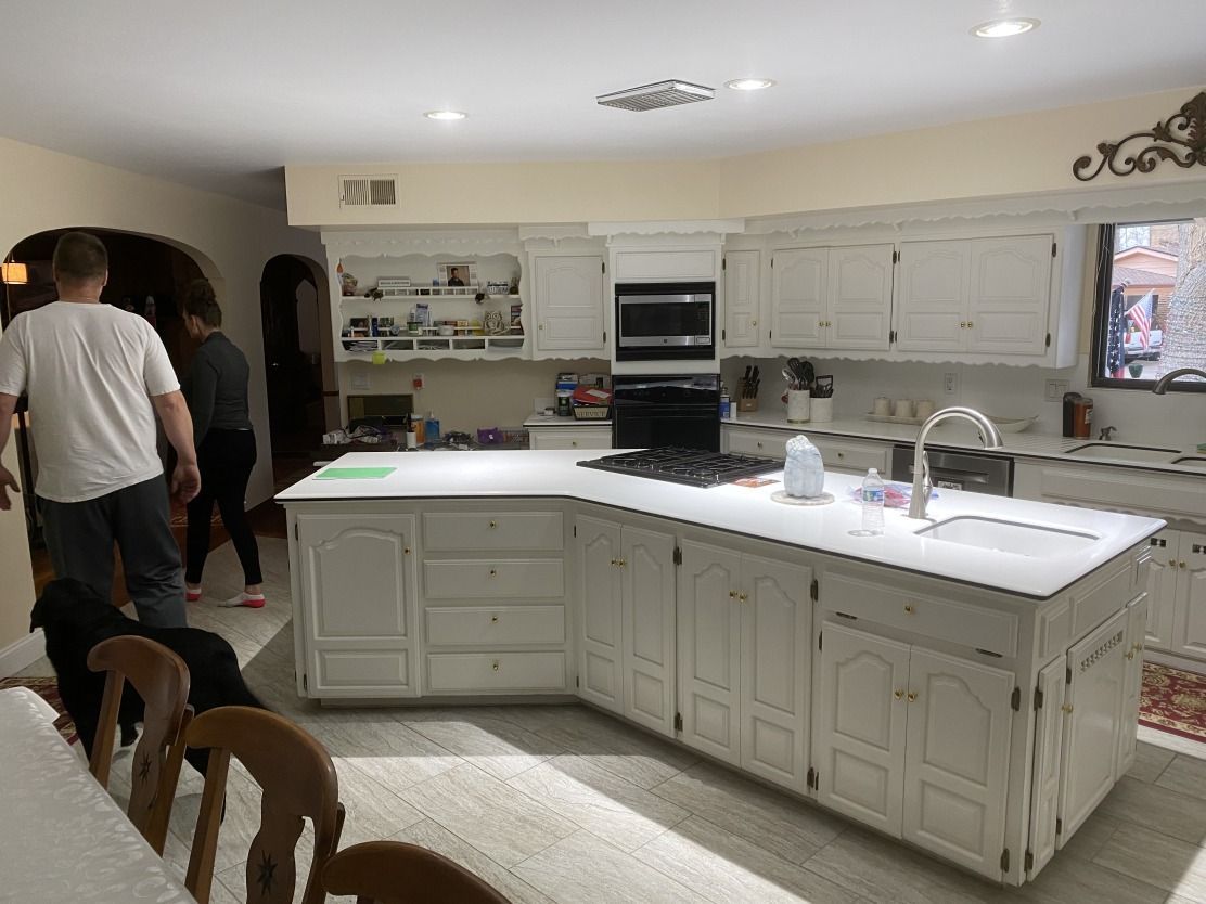 A kitchen with white cabinets and a large island.