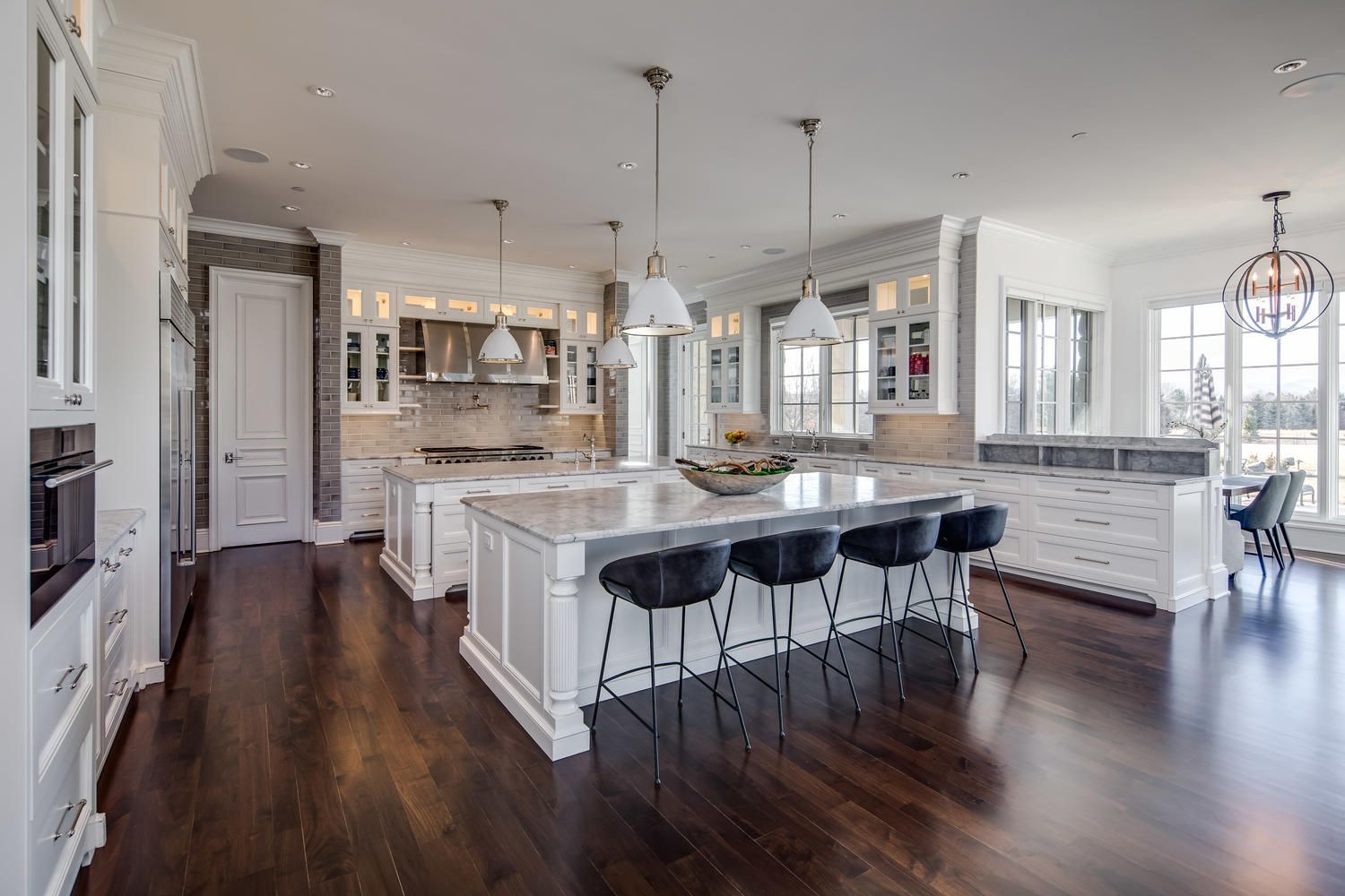 A large kitchen with white cabinets and a large island.