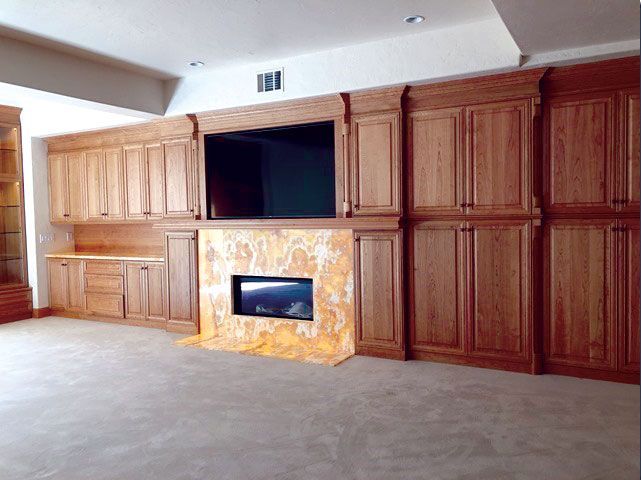 An empty room with wooden cabinets and a fireplace