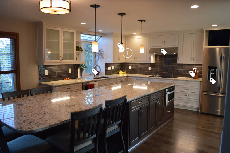 A large kitchen with white cabinets , granite counter tops , stainless steel appliances and hardwood floors.