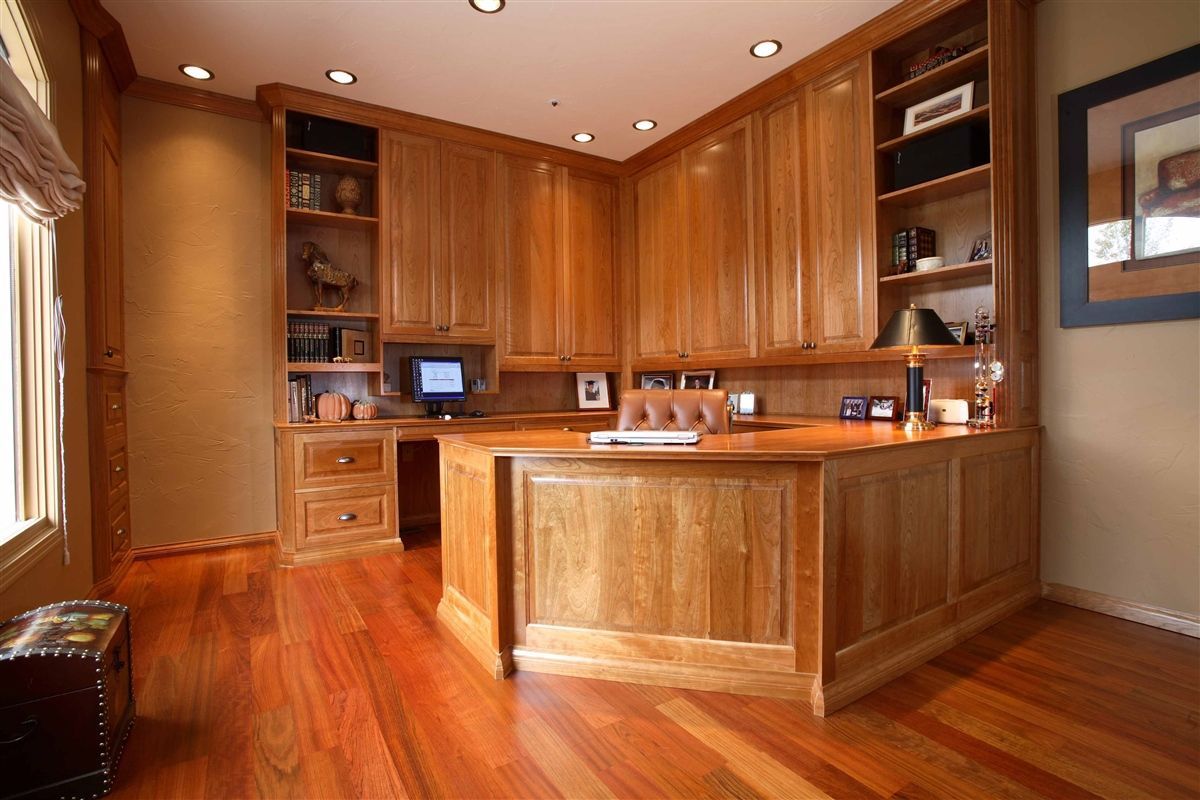A home office with wooden cabinets and hardwood floors