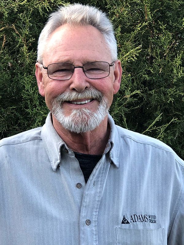 A man with a beard and glasses is smiling for the camera.
