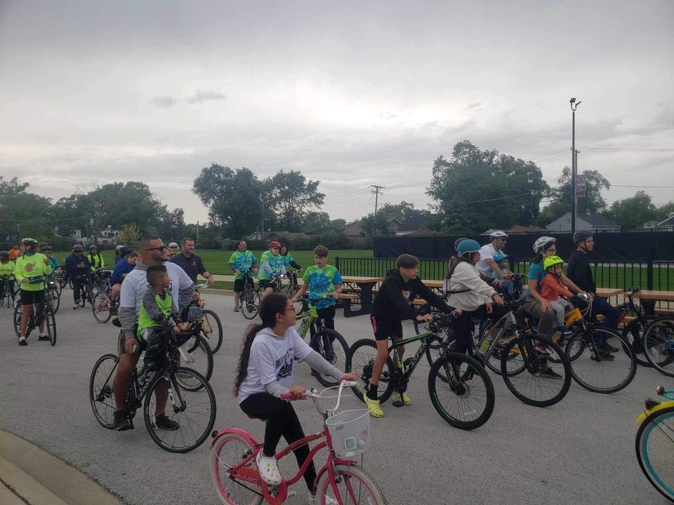 A group of people are riding bicycles down a street.