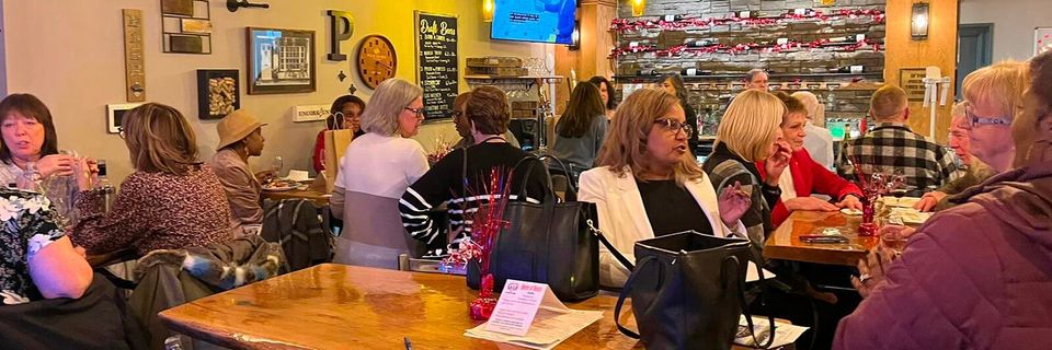 A group of people are sitting at tables in a restaurant.