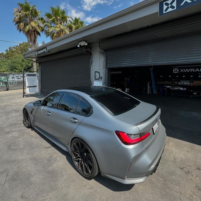 Silver BMW M3 parked outside XWRAPS service center in LA, showcasing premium windows tinting and PPF (Paint Protection Film) installation