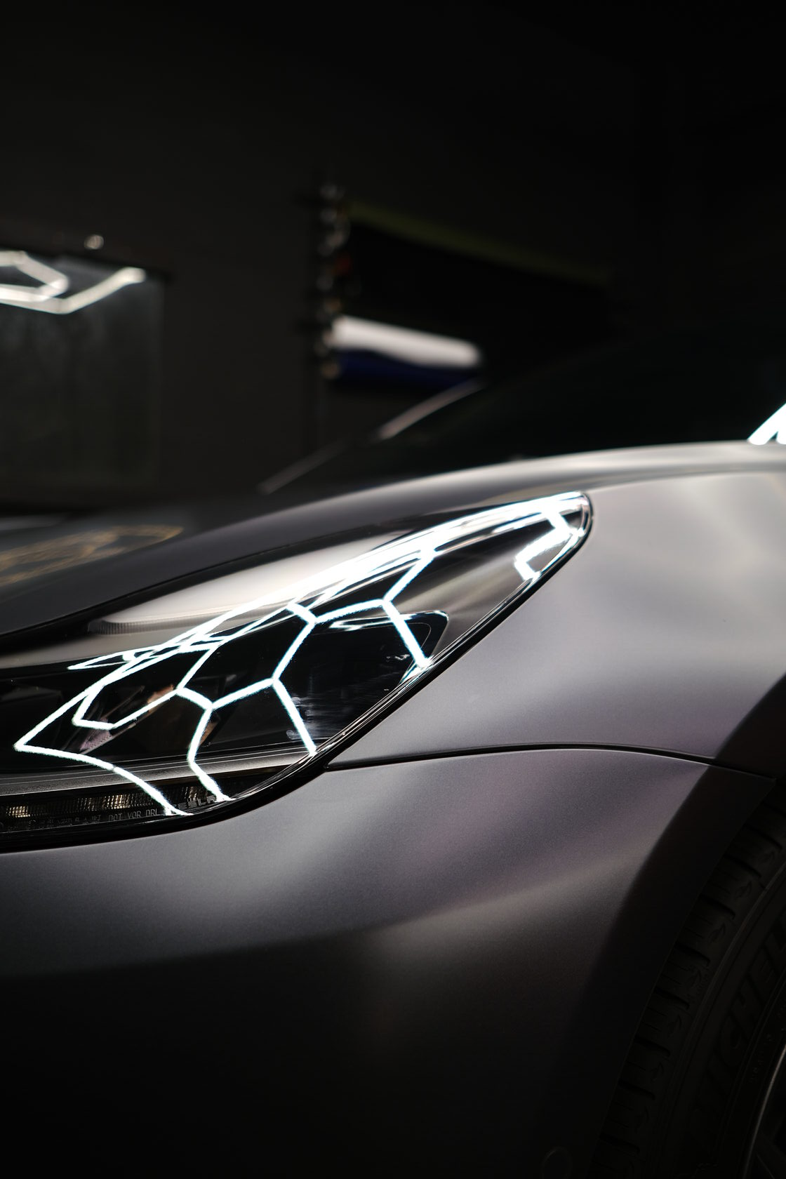 A close up of the headlight of Tesla at XWRAPS, a leading car wrap shop in LA.