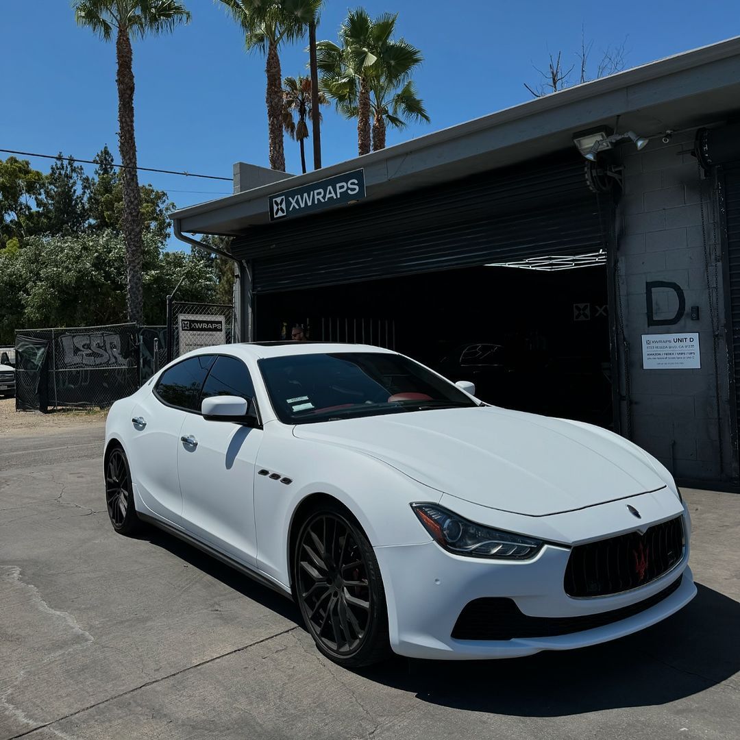 Sleek white Maserati Ghibli with premium window tinting at luxury auto shop in Los Angeles